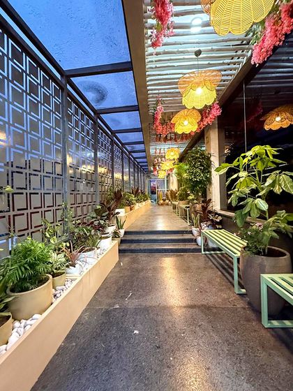 The main walkway at Organic Creamery, lined with planters filled with a variety of foliage. The design guides customers through the space while surrounding them with greenery.