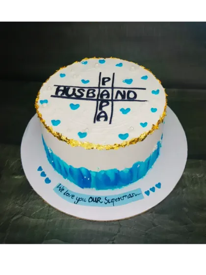 A cake celebrating a man who is both a husband and a papa. This chocolate truffle cake features a crossword design and is dedicated to "Our Superman."