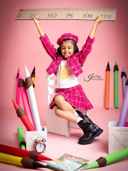 A joyful, energetic pose that perfectly captures the spirit of being seven. The combination of props and the child's expression makes this a standout shot.
