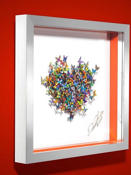 A framed butterfly heart sculpture by David Kracov. His work, which blurs the line between sculpture and story, speaks to the dreamer in every generation and aligns perfectly with our gallery's vibrant aesthetic.