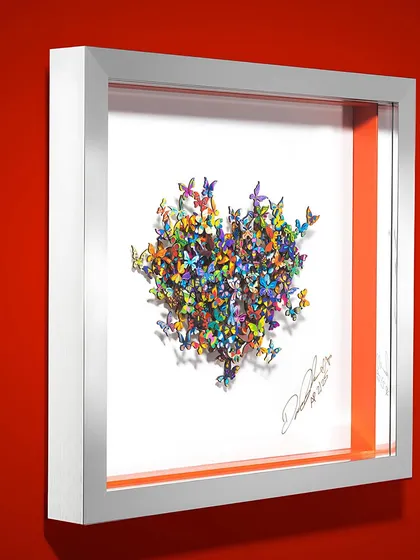 A framed 'My Heart is all Flutter' by David Kracov. Hundreds of hand-cut, vibrant butterflies come together to form a heart, each one an ode to joy.