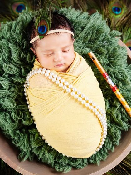 Another beautiful take on the Krishna theme, with a sleeping newborn wrapped in yellow and encircled by a fan of peacock feathers.