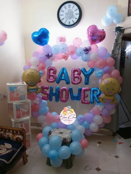 A pastel-colored baby shower ring decoration with 'BABY' blocks and cute baby foil balloons.