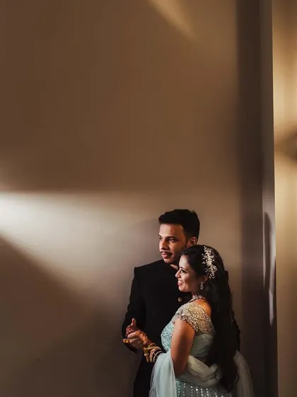 A beautifully lit portrait in a hallway, using wall sconces to create pools of light. This shot of Shweta and Onkar has a cinematic and intimate feel.