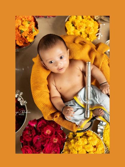 Celebrating Janmashtami with our own little Krishna. This festive setup features vibrant flowers and a tiny flute, perfect for capturing a special cultural moment.