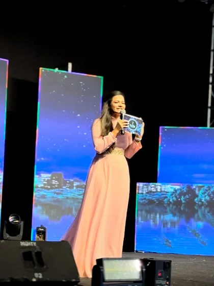 Addressing the audience from the stage during a grand Sangeet event.