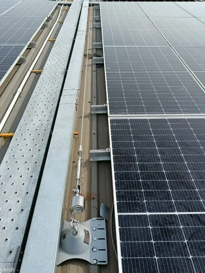 A close-up of the rooftop installation, showing the secure mounting structures and integrated walkways. We prioritize safety and ease of maintenance in all our designs, ensuring the longevity and efficiency of the solar plant.