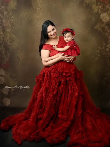 Mother and daughter in a sea of red. The mother's magnificent ruffled gown and her daughter's matching dress create a dramatic and loving portrait.