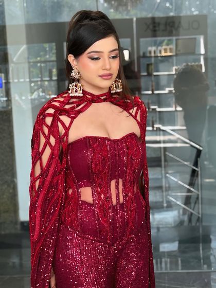 This red jumpsuit with a cape called for an equally dramatic makeup look. The high ponytail and sharp makeup were the perfect match.