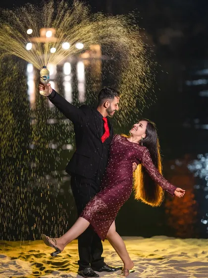 Let's celebrate your love with a bang. A champagne pop at night on the sandy banks of the river creates a fun, celebratory, and dynamic shot that’s full of joy and energy.