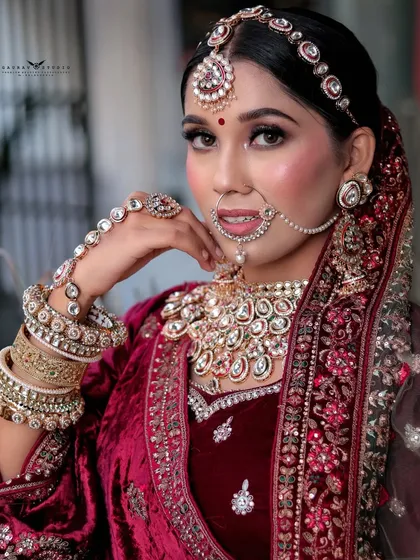 A close-up focusing on the intricate hand jewelry (hathphool) and the rich texture of the maroon velvet.