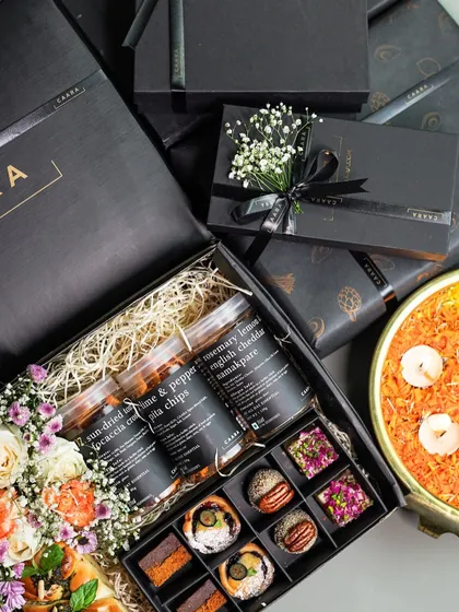 A look inside our signature Sancho Box for Diwali, a true celebration of flavour. This gourmet gift hamper features an assortment of our modern Indian sweet bites alongside savoury jars of sun-dried tomato & pepper focaccia chips and rosemary lemon English cheddar namakpare, all beautifully arranged with fresh flowers.