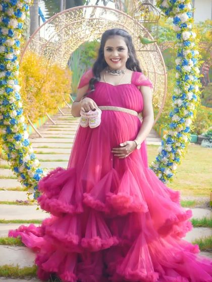 A beautiful portrait in a floral archway, with the mom-to-be holding up a pair of baby shoes. This combines a stunning location with a classic announcement prop.