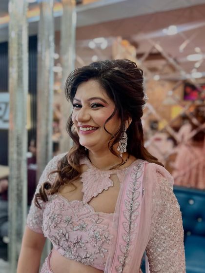 A beautiful, happy client in a pink sequin lehenga. Her smile says it all. We gave her a soft, romantic hairstyle and glowing makeup.