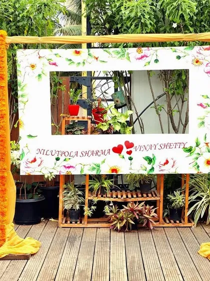 A fun and floral photo frame for guests at a Haldi event, decorated with marigolds and personalized with the couple's name.