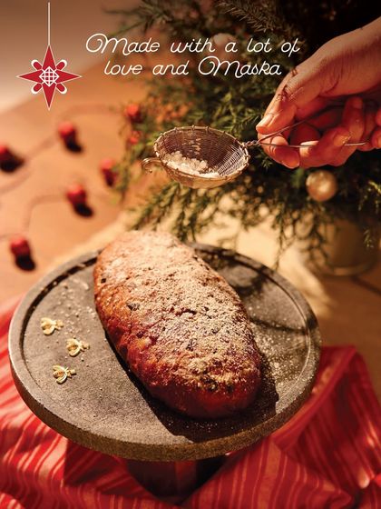 Dusting a freshly baked Christmas Stollen with powdered sugar. It's the perfect finishing touch for this festive bread.