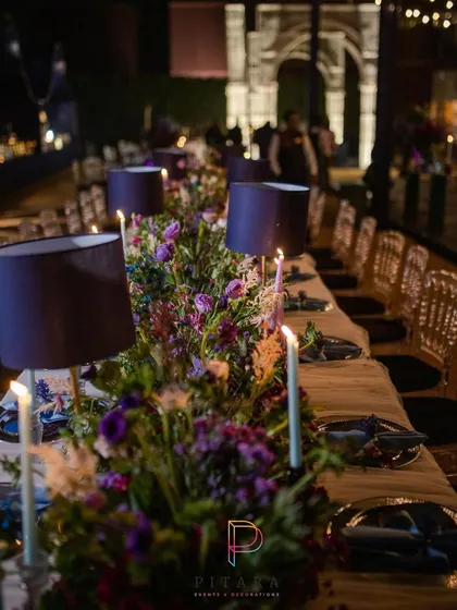 A long shot of the dining table, showing the repeating lampshades and floral runners that created a sense of rhythm and elegance down the length of the table.