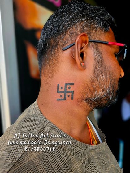 A bold Swastika tattoo placed on the neck, a visible symbol of faith.
