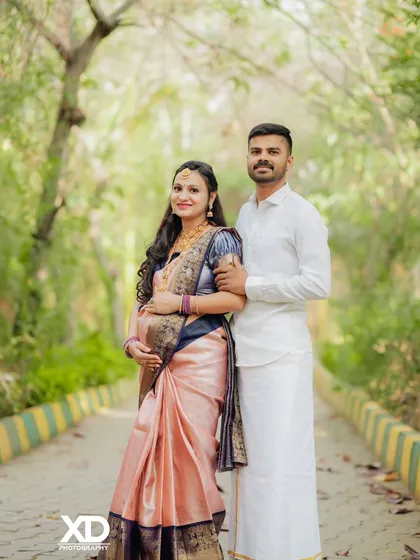 A classic couple's portrait on a tree-lined path, capturing their happiness in a natural outdoor setting.