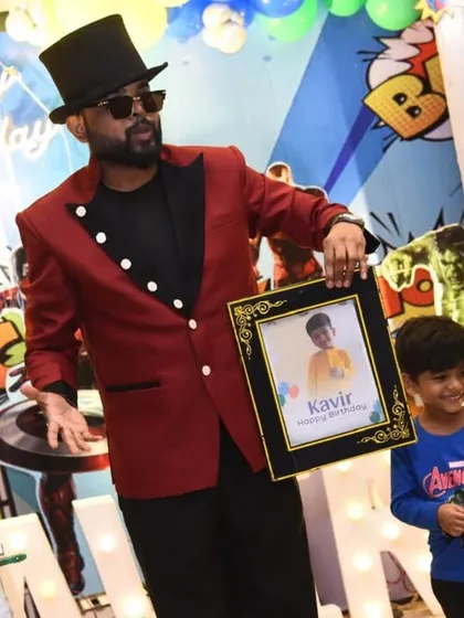 Magically revealing a personalized photo frame for the birthday boy, Kavir, at his superhero party. The decor, featuring Hulk and Captain America, completes the scene.