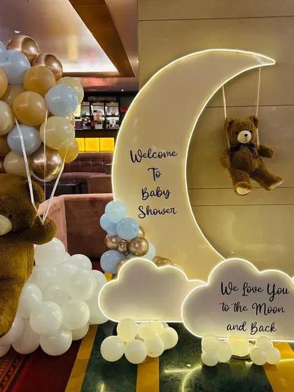 There is nothing sweeter than a teddy bear theme, and this 'We Love You to the Moon and Back' setup is one of our favorites. The soft lighting, cloud-like balloons, and adorable bears create a warm, dreamy atmosphere for a truly memorable baby shower.