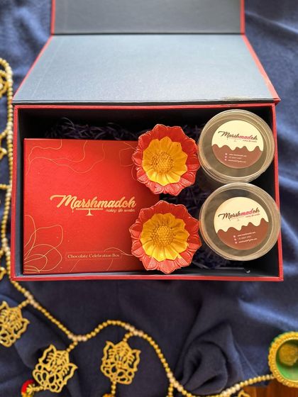 This hamper configuration includes a box of my chocolate celebration bites and two jars of assorted goodies, paired with decorative flower-shaped diyas for a complete Diwali gift.