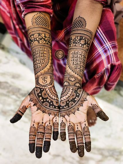 A classic bridal henna with a personal touch for Saliha. Her initial, S, is beautifully integrated into the design on her forearm, surrounded by detailed patterns.