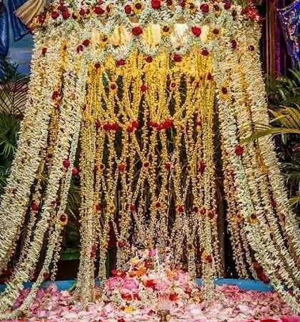 This is a very traditional style of floral decoration, often used for temple events or religious ceremonies at home. I created a canopy effect using countless strings of fresh jasmine and tuberose (rajnigandha), with accents of red roses.