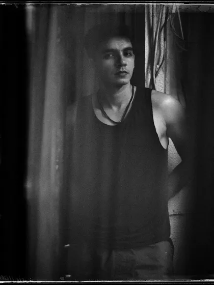 A moody, grainy portrait of Lakshvir. The texture of the film and the dark tones give this image a raw, vintage feel.