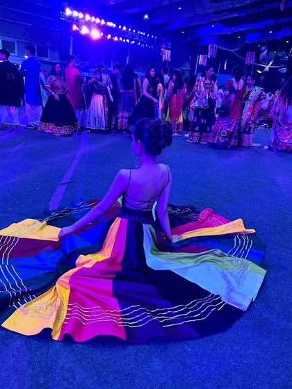 A candid shot from a Navratri event, with my colorful ghagra spread out. The vibrant colors and festive lights are a huge inspiration for my Garba choreography.