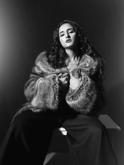A glamorous, old-Hollywood-style portrait in black and white. The soft, diffused lighting and the faux fur coat create a timeless and sophisticated look.