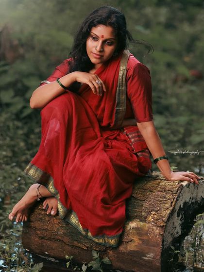 A rustic, village-themed series inspired by the movie 'Kanthara'. The model is styled in a simple red saree, captured in a natural, watery landscape to evoke a sense of raw, earthy beauty.