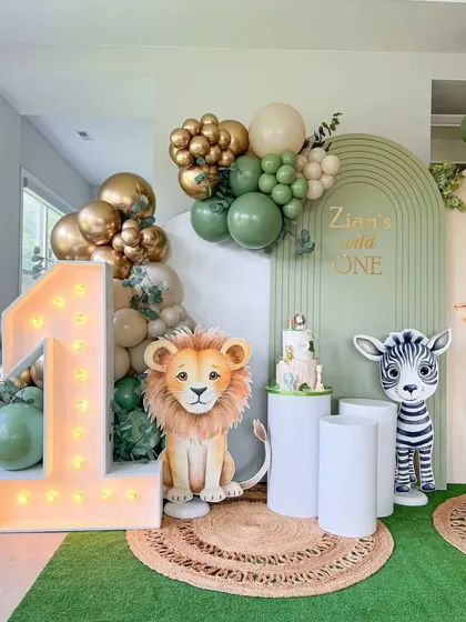 We incorporate marquee numbers into our themes, like this light-up '1' alongside a lion cutout for a memorable first birthday photo spot.