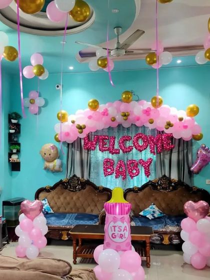 A wide view of the pink and gold "Welcome Baby" room decoration.