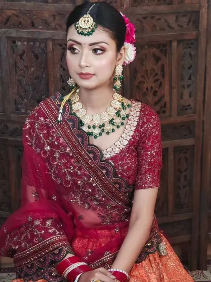 A simple and elegant look for a pre-wedding function. The model wears a green beaded necklace with a red and orange lehenga.