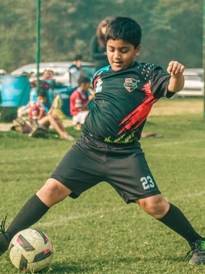 A young player prepares to strike the ball, demonstrating good form and concentration.