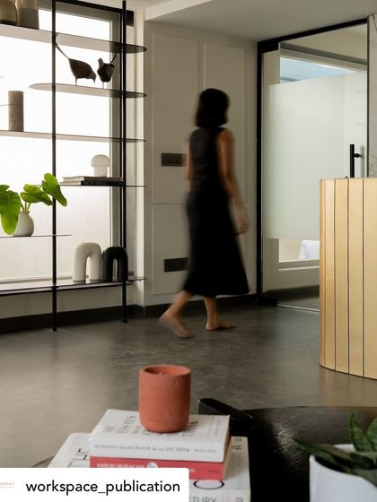 This shot captures the sense of movement and flow through the office's open-plan areas, leading towards a private washroom with a distinctive fluted vanity.