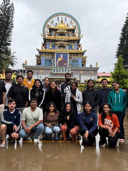 A group poses in front of the Golden Temple in Bylakuppe, part of our Coorg exploration. We mix culture with adventure.
