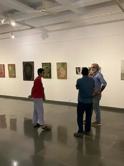 Visitors in conversation at the 'ME, AMMA, WE' exhibition.