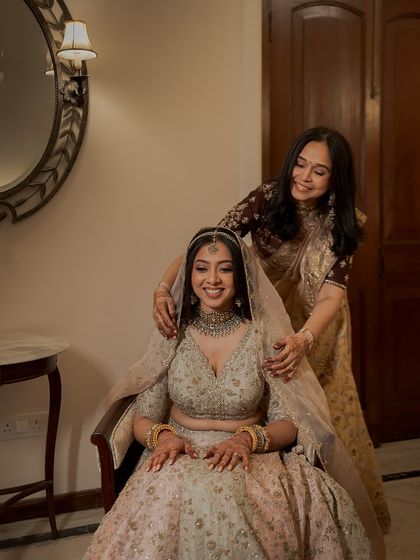 A heartfelt moment between a bride and her mother. As her mom adjusts her veil, the bride's soft, radiant makeup ensures she looks serene and beautiful for her big day.