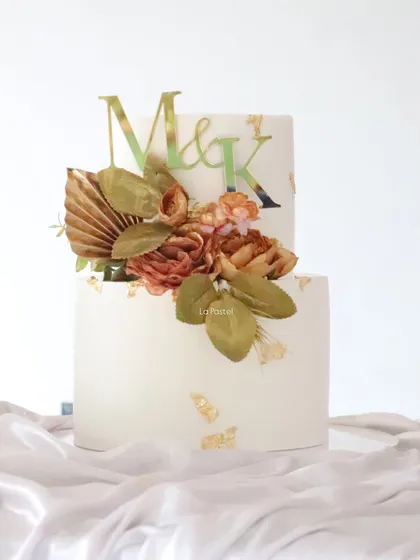 A closer look at the details of this vintage-boho cake, showing the texture of the dried florals and the pretty custom initial topper.