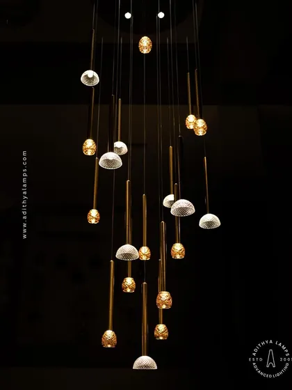 The multi-pendant chandelier viewed from below, showing the intricate patterns of the textured glass shades. This fixture creates a beautiful light pattern on the ceiling and floor.