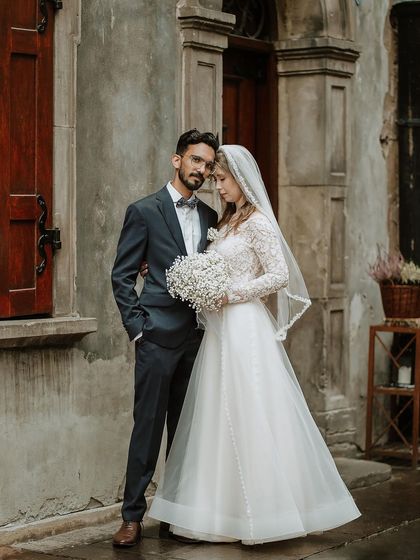A timeless portrait of Shahin and Michalina on their wedding day in Poland. This image captures the elegance of their union against the historic architecture, a true blend of cultures.
