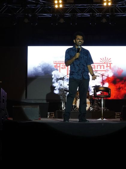 Naveen Richard performing his set on a professionally lit stage at IIM Vizag.
