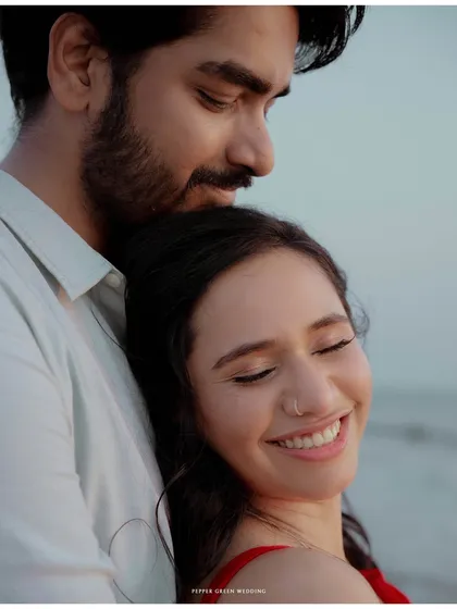 A quiet moment of peace and affection as the sun sets over the ocean. This is the serene side of a beach pre-wedding story.