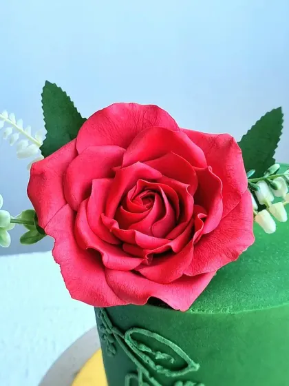 A close-up of the handmade red sugar rose, showing the detail in each petal.