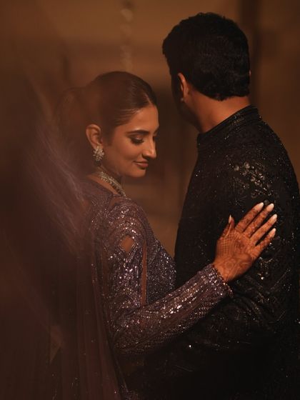 An artistic, intimate shot of Sree and Mohnish. The focus is on their connection, with their glamorous sangeet outfits creating a beautiful frame.