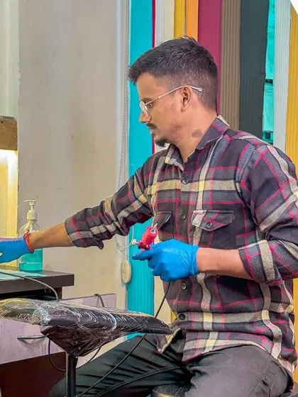 One of our talented artists, focused on setting up his station. We use sterilized, single-use equipment for every client to ensure complete safety.