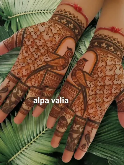 A creative design featuring parrots on the back of the hand, with their tails forming part of the pattern.