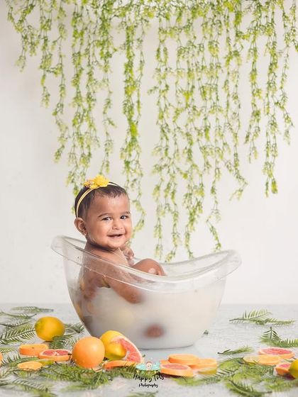 Our splash sessions are all about capturing pure joy. This baby's happy expression says it all, surrounded by fresh lemons and greenery.